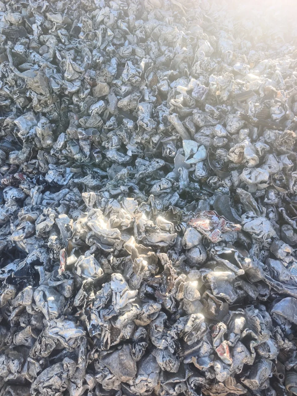 Montón de chatarra de aluminio compactada, materia prima que REQ Aluminium funde y convierte en lingotes.